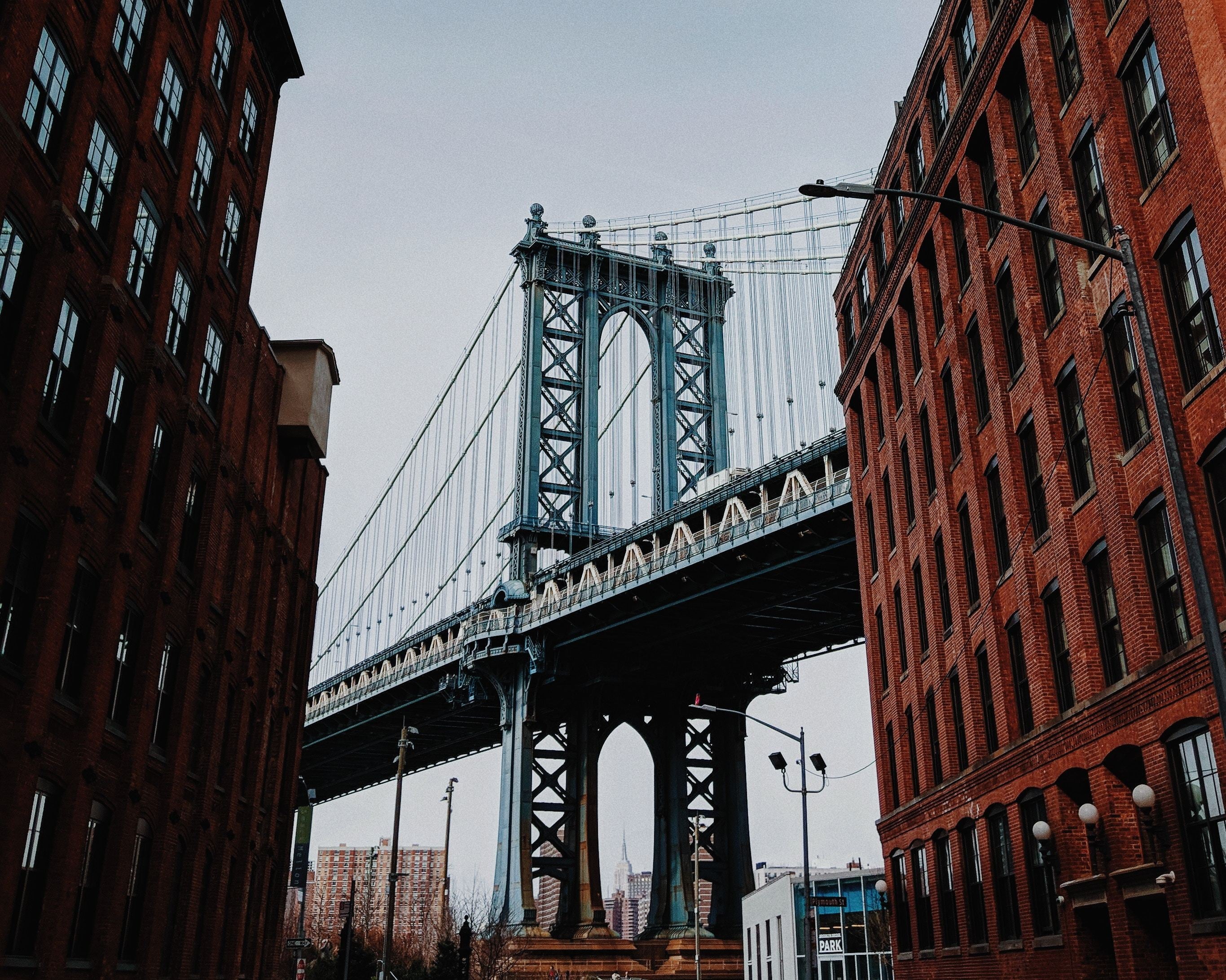 Brooklyn Bridge in the middle of red brick buildings.